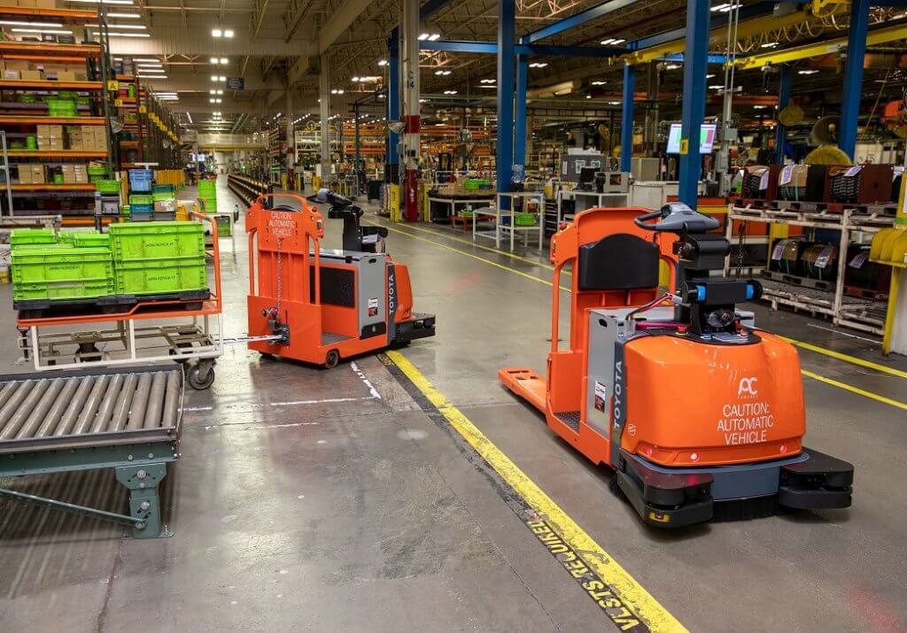 Dos carretillas elevadoras automatizadas trabajando en un almacén