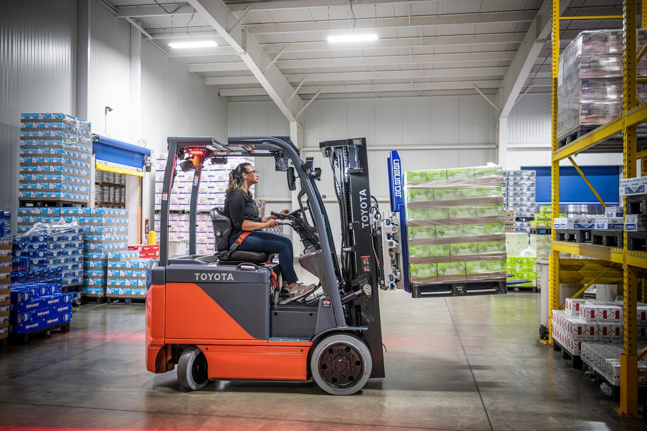 Carretilla elevadora eléctrica central utilizada en el almacén para levantar una paleta de cerveza Bud Light 