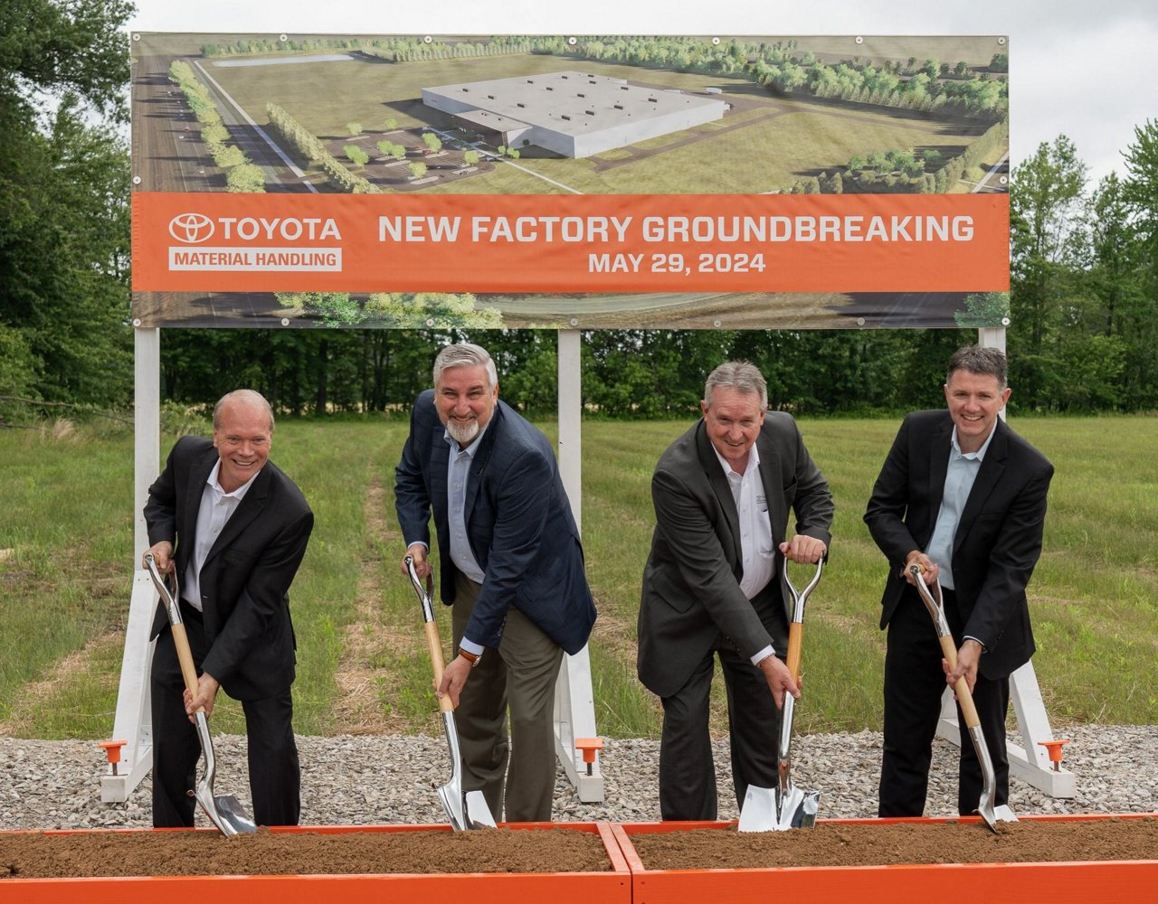 group photo in front of groundbreaking sign with governor of Indiana and TMH executives holding shovels 