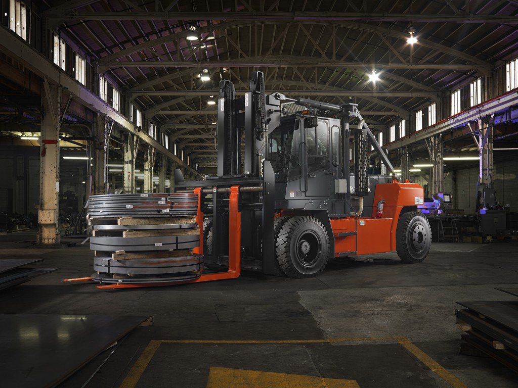 High Capacity IC Pneumatic forklift carrying 3 large tires in warehouse