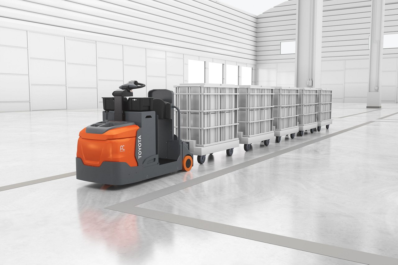 Tracteur de remorquage orange conçu pour transporter des produits et des matériaux dans un entrepôt ou un centre de distribution 