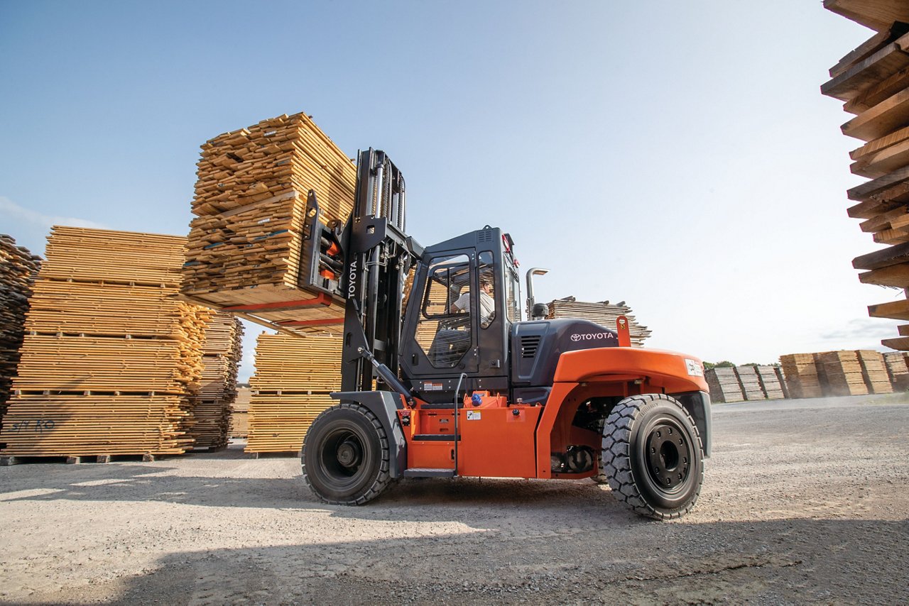 Toyota forklift lifting wooden pallets outdoors in a lumbar courtyard 