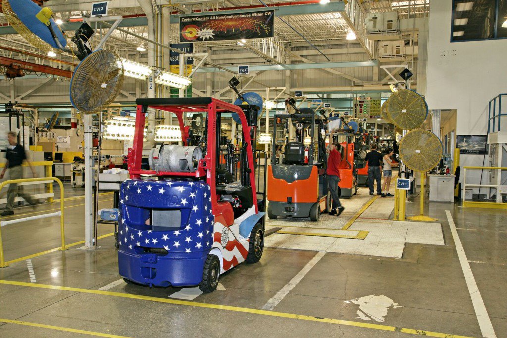 Muchas carretillas elevadoras se alinearon en el almacén, con la carretilla elevadora en la parte delantera pintada para parecerse a la bandera de EE. UU 