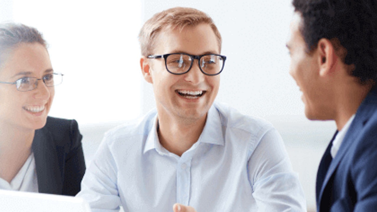 2 hombres de negocios y 1 mujer de negocios sonriendo y hablando 