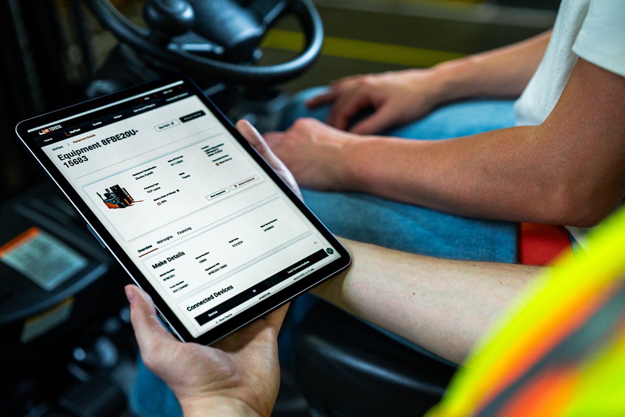 Gros plan d’un homme tenant un iPad qui montre le tableau de bord MyToyota où les utilisateurs peuvent voir leur équipement
