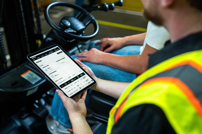 Man holding IPad that shows MyToyota dashobard where users can view their fleet information 