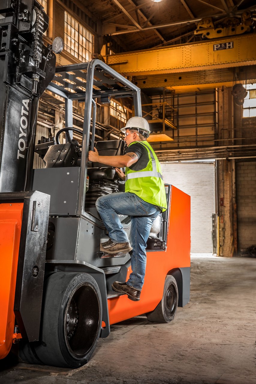 Man Entering Toyota High Capacity Large IC Pad Forklift In Warehouse 