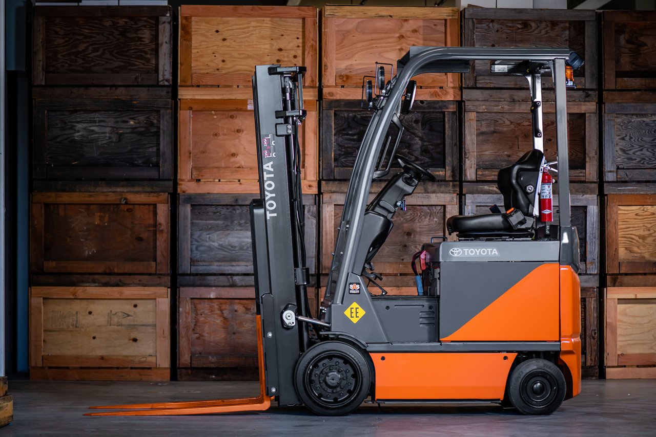 Chariot élévateur électrique Toyota Core garé contre un mur en bois à un angle latéral