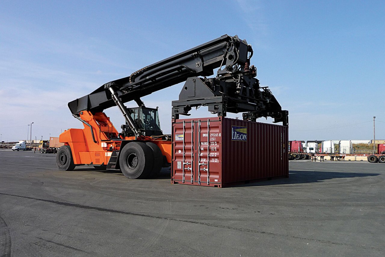 Toyota Reach stacker lifting a frieght container in an outdoor loading lot