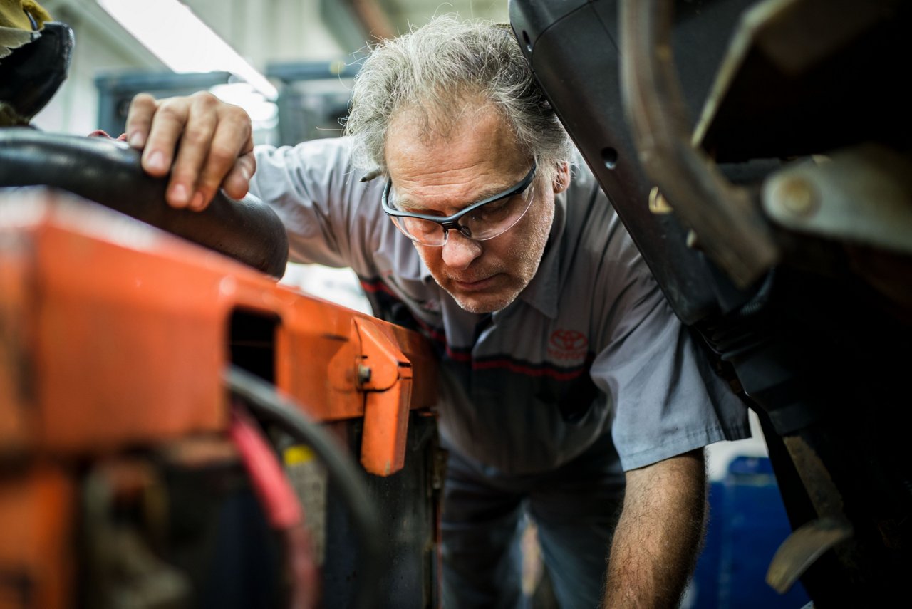 Un técnico de Toyota mirando el motor de una carretilla elevadora 