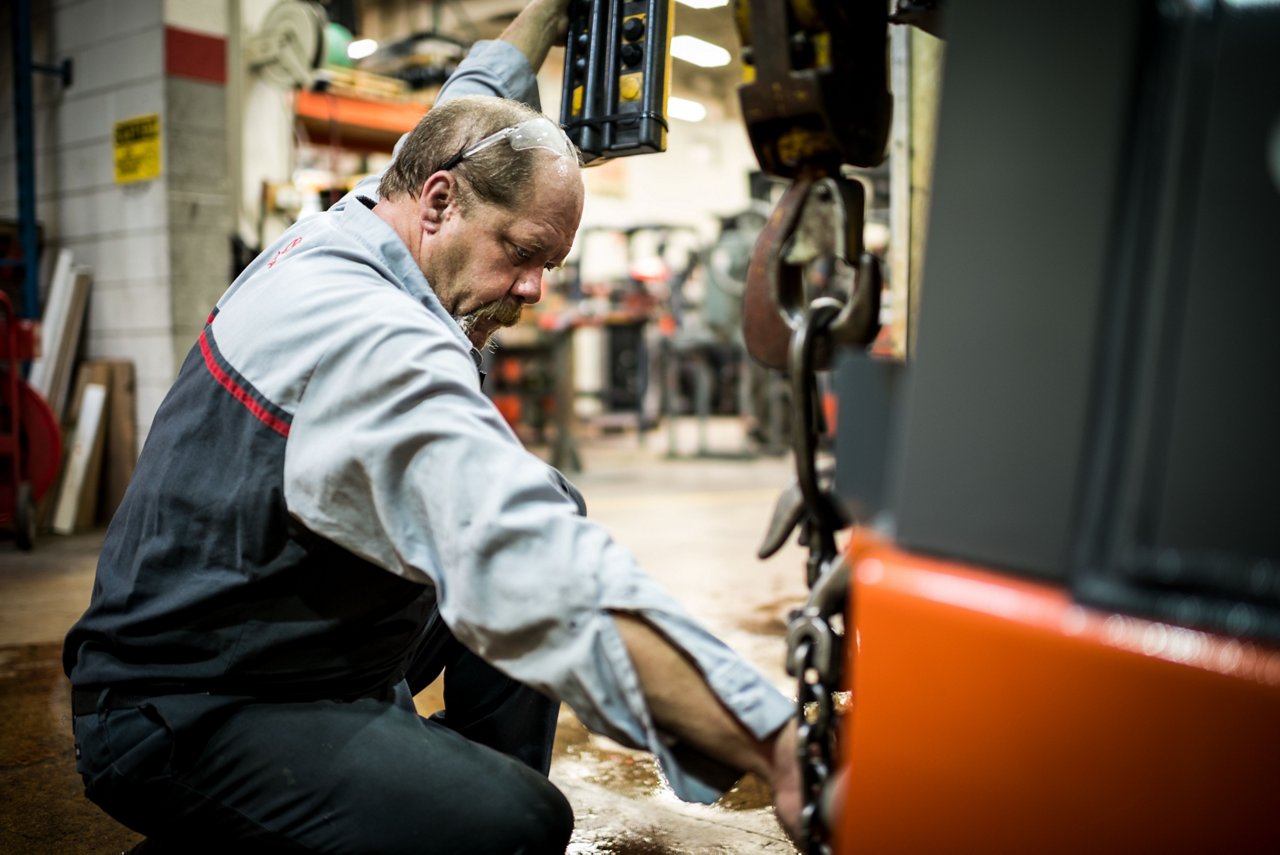 Un técnico de Toyota dando servicio a una carretilla elevadora en un almacén 