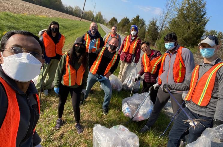 Un selfie avec 10 bénévoles tenant des sacs poubelles sur le bord de la route