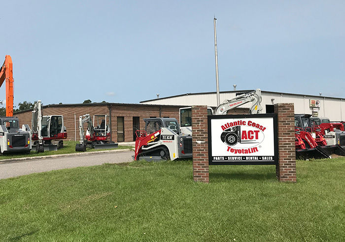 edificio de ladrillo con equipo rojo de manejo de materiales en el frente en Wilmington, NC