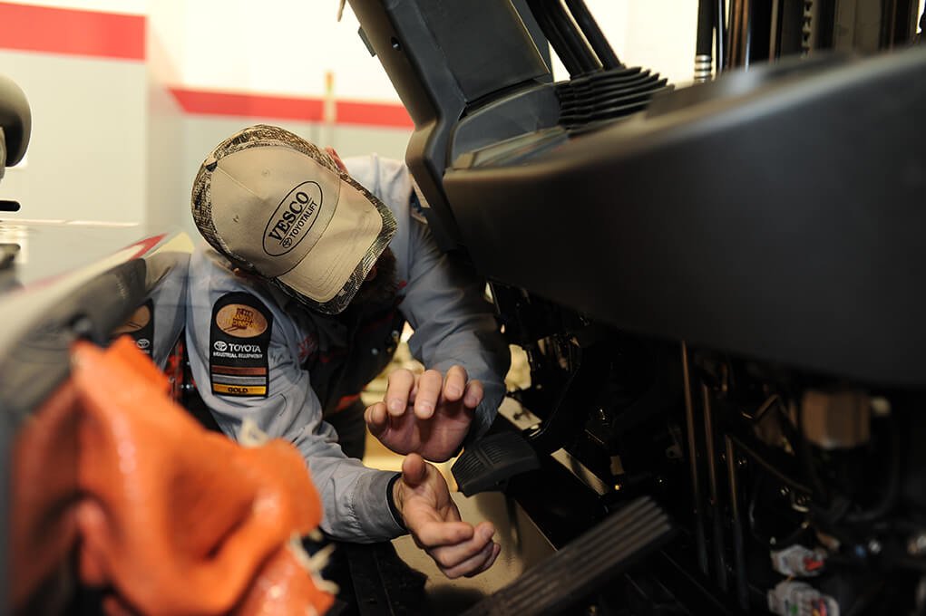 Técnico realizando una inspección de frenos de seguridad de montacargas en una carretilla elevadora Toyota