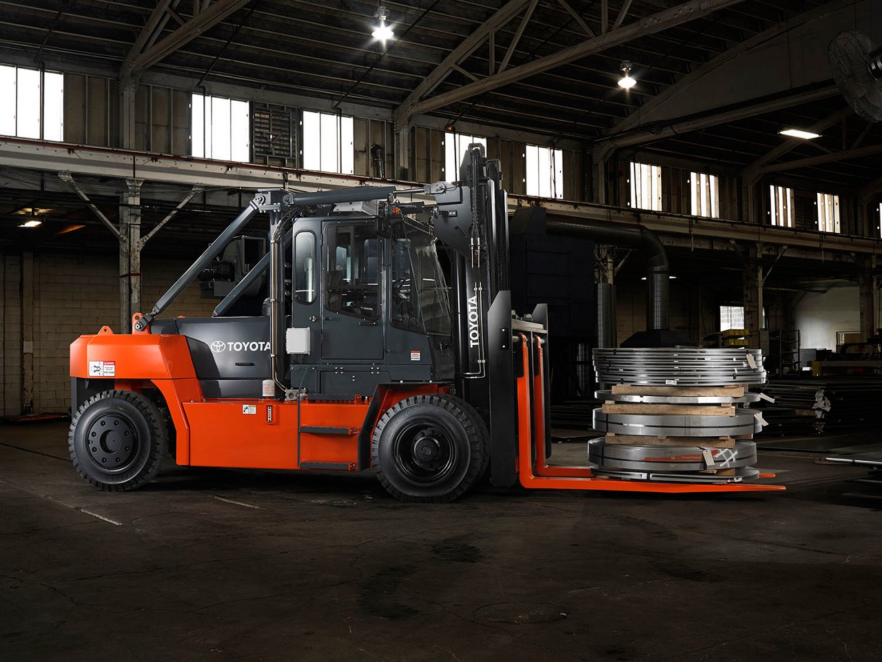 High Capacity IC Pneumatic forklift carrying 3 large tires in warehouse