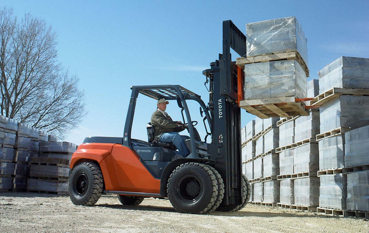 Carretilla elevadora neumática Toyota Grand IC que eleva dos paletas de material en un lote al aire libre