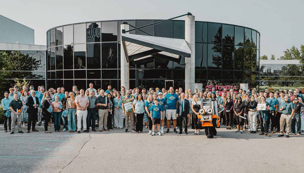 Groupe d’employés Toyota dehors souriant avec le destinataire de Make a Wish
