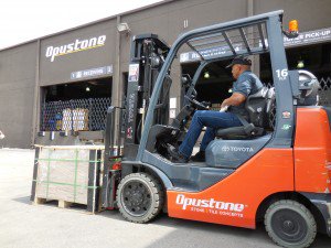 Hombre conduciendo carretilla elevadora opustone en lote al aire libre