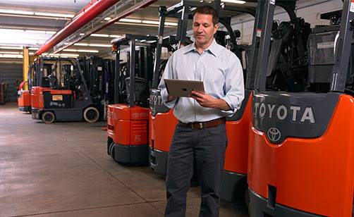 Businessman with tablet standing in a Toyota dealership