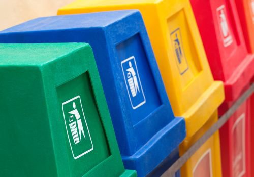 4 contenedores de reciclaje de diferentes colores alineados uno al lado del otro