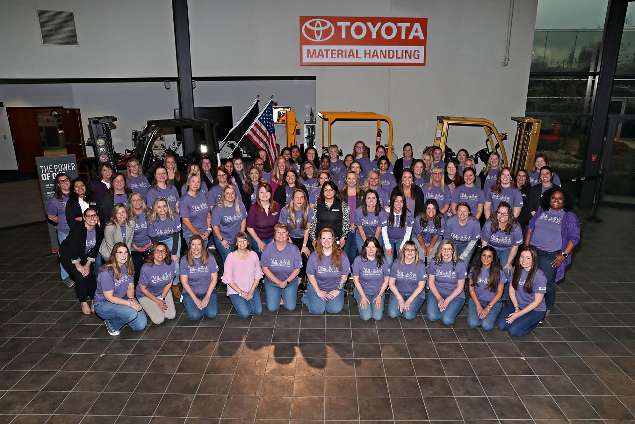 65 empleadas de Toyota sonríen para una foto grupal con camisetas a juego